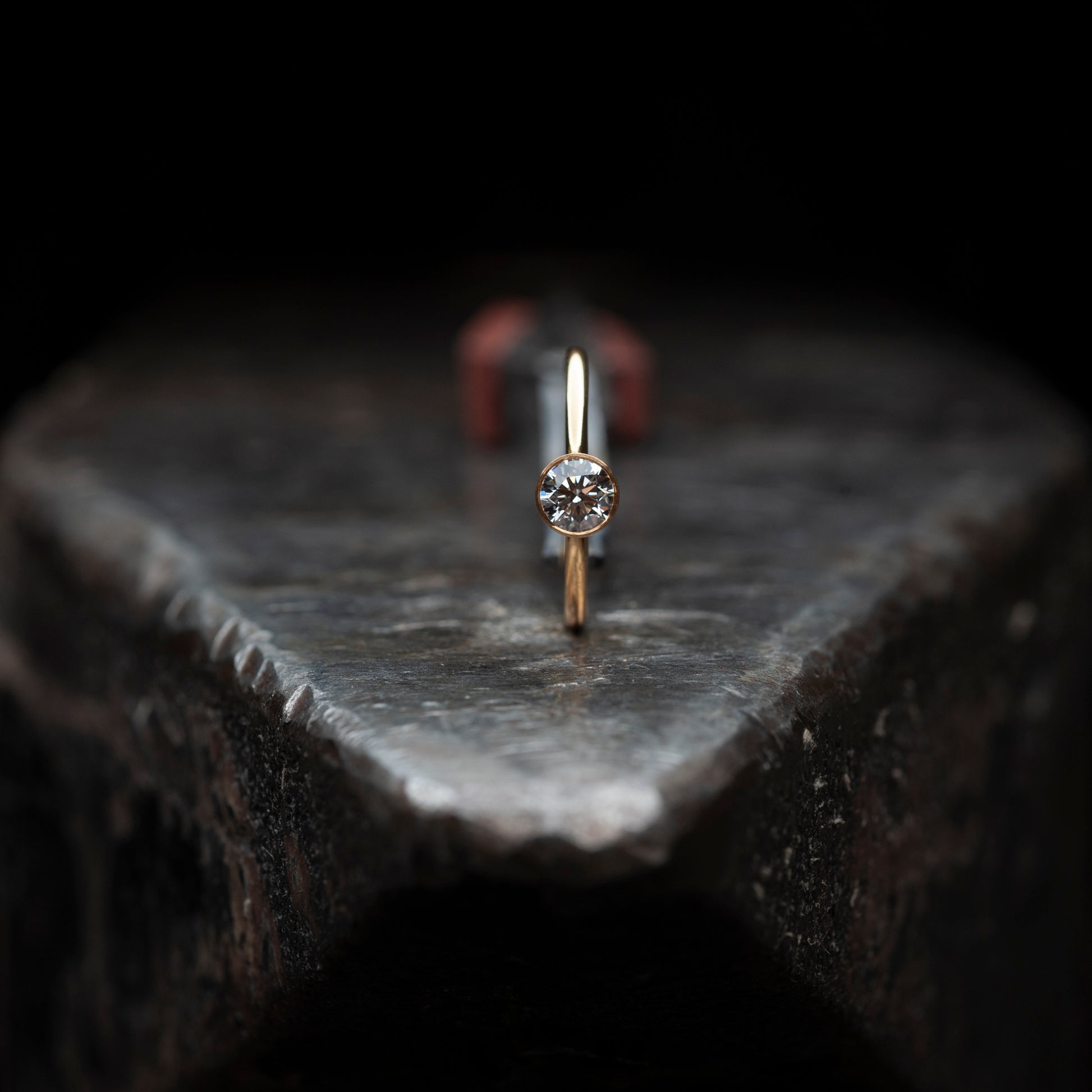 Der Ring hochkant stehend auf einem massiven Amboss